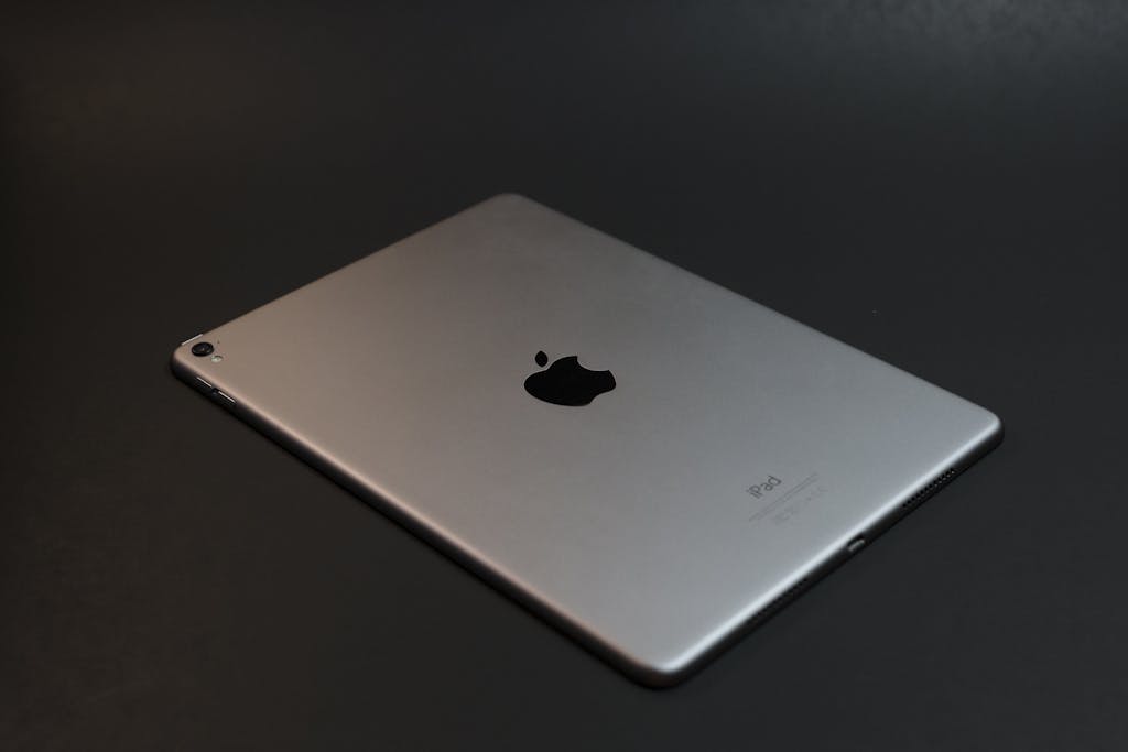 A modern silver tablet with a sleek design on a dark surface, showcasing advanced technology.